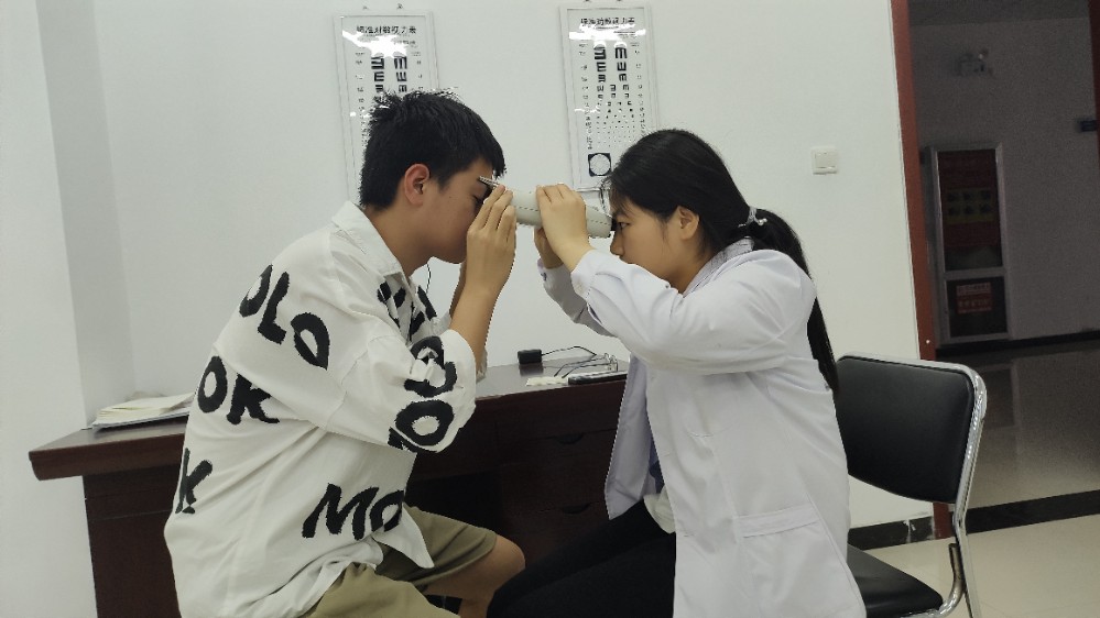 眼视光的同学用仪器观察眼睛情况.jpg